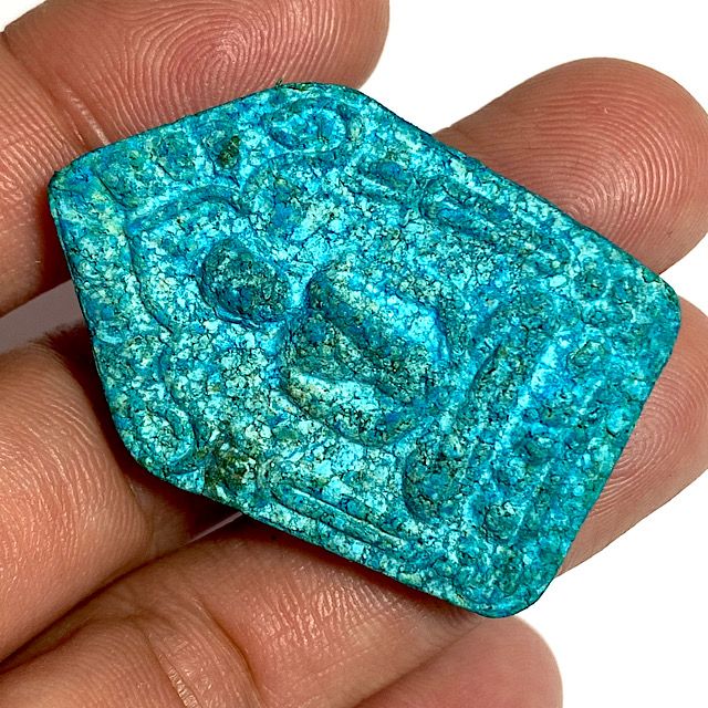 Front face of the amulet held at a 45 degree angle in the hand for size comparison and clear inspection