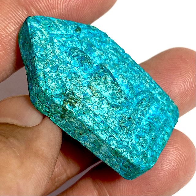 Amulet held in the hand view from the edge at a 45 degree angle to see the depth of relief and the features of the edges of the amulet for natural aging properties