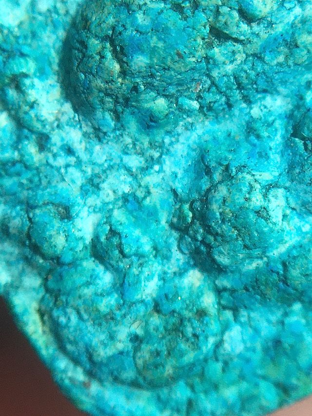 Macro close up image of the bottom left corner of the front face of the amulet for inspecting the sacred admixture