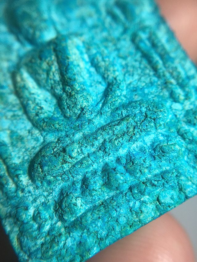 Angled close up macro image of the details and features of the front face of the amulet