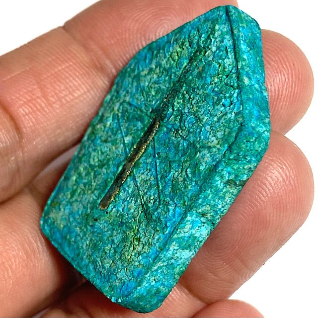 Image of the rear face of the amulet held in my hand seen from a 45 degree angle leaning to the right