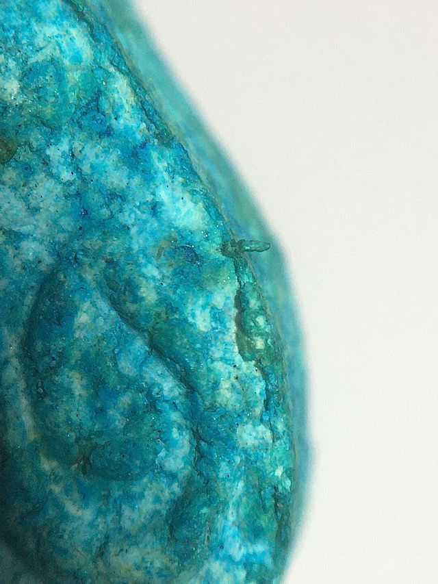 Extreme macro close up of the formations on the rim of the edge of the front face of the amulet showing natural signs of aging and authentic features