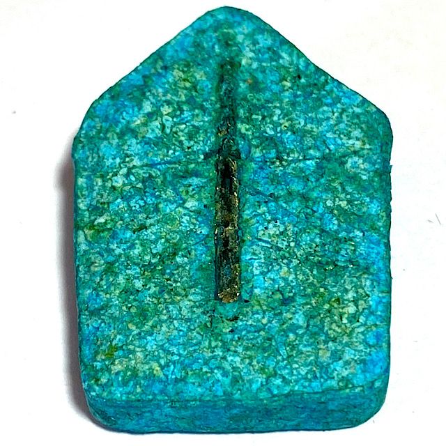 Rear face of the amulet laid flat on a white background scene from the bottom edge revealing the complete surface of the rear face in perspective